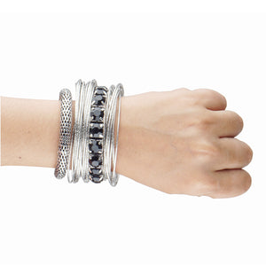 Bunch of chunky silver bangles with dangling crystals and chains